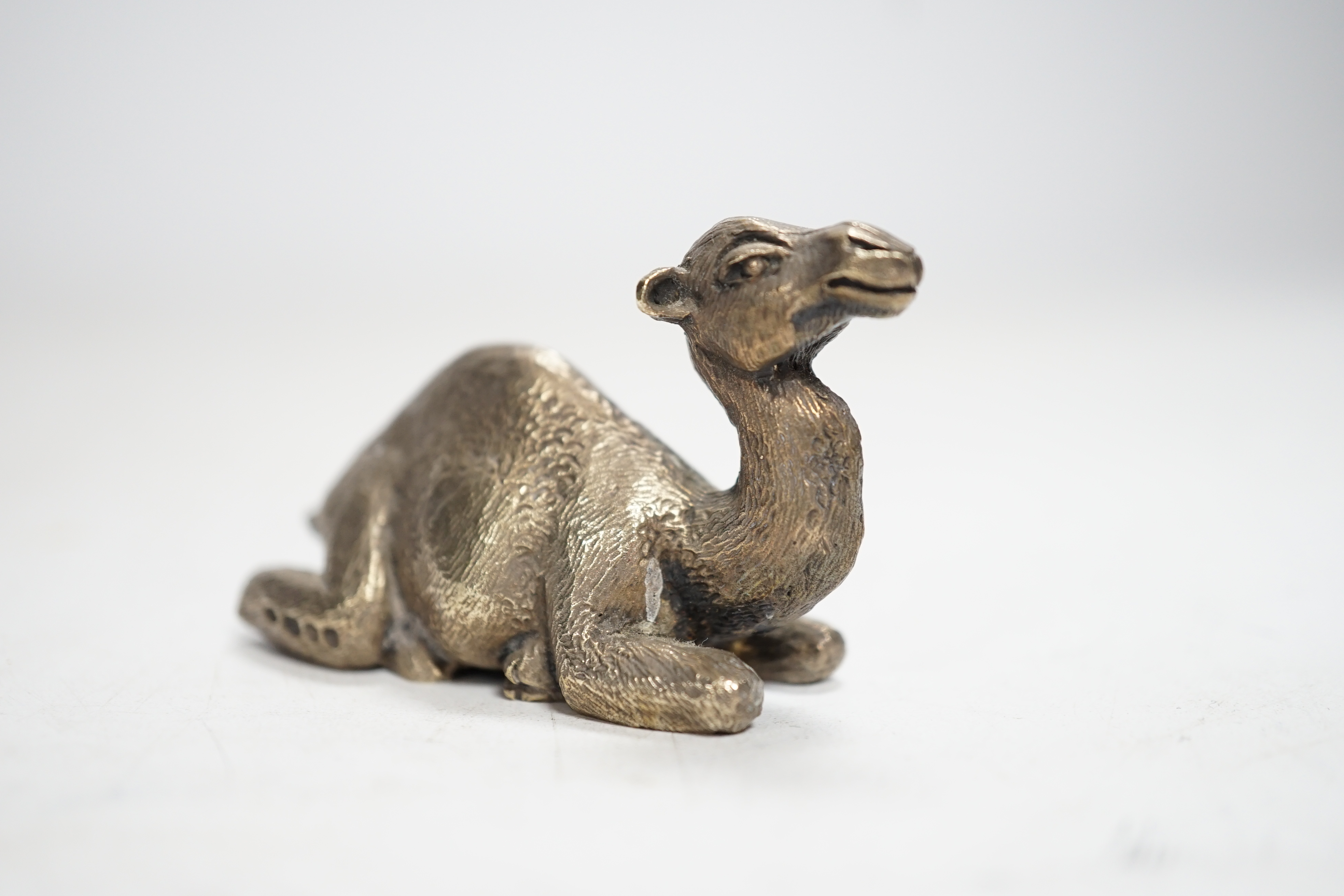 An Elizabeth II miniature silver model of a recumbent camel, by Stuart Devlin, London, 1979, length 58mm.